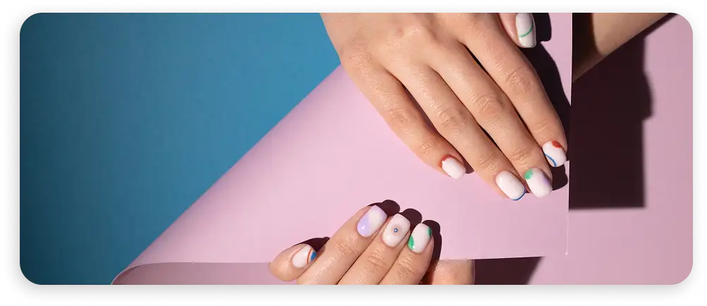 Renkli pastel arka planlarda modern geometrik tırnak sanatıyla şık kadın elleri, yaratıcı bir güzellik kompozisyonunda.